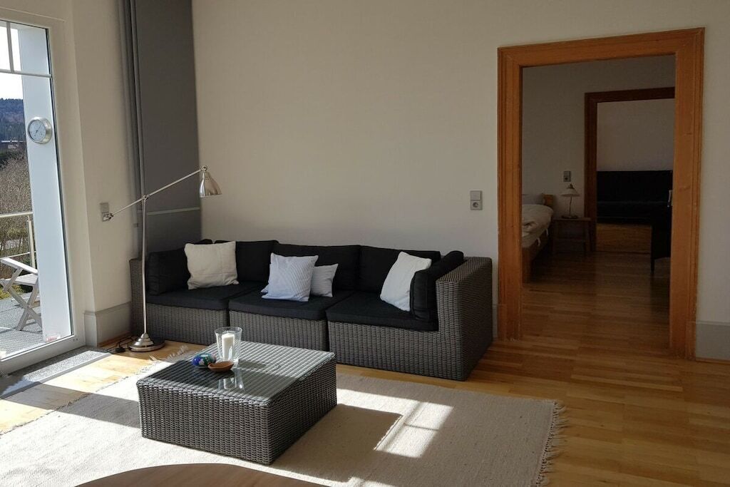 Un salon moderne comprenant un canapé, une table basse et une lampe.