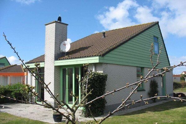 A single-story house with a green exterior and a brown roof. - Holiday home with 3 bedrooms (Julianadorp)