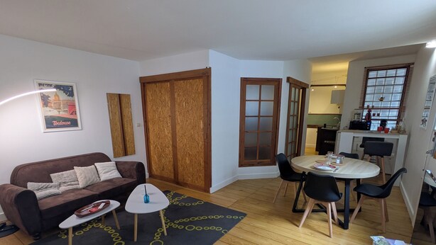 Un salon comprenant un canapé, une table basse et un coin repas avec des chaises et une table.