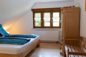 A bedroom with a bed, a window, a radiator, and a wooden wardrobe. - 2 Kleinklausenhof Farm (Vöhrenbach)