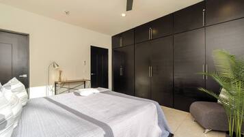 Un dormitorio moderno con cama, escritorio y armario.