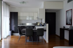 A modern kitchen with a dining area, featuring a central island, black chairs, and a black cabinet. - A bright 85 square meters apartment, perfect for four people, located on the second floor of a modern building with an elevator (NOT accessible to people with disabilities).The property is situated opposite the Monza circuit, near the first chicane and t (Biassono)