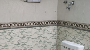 Une salle de bain standard équipée de toilettes, d’un bidet et d’une douche.