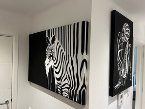 Een muur met twee grote zwart-wit kunstwerken van zebra's.