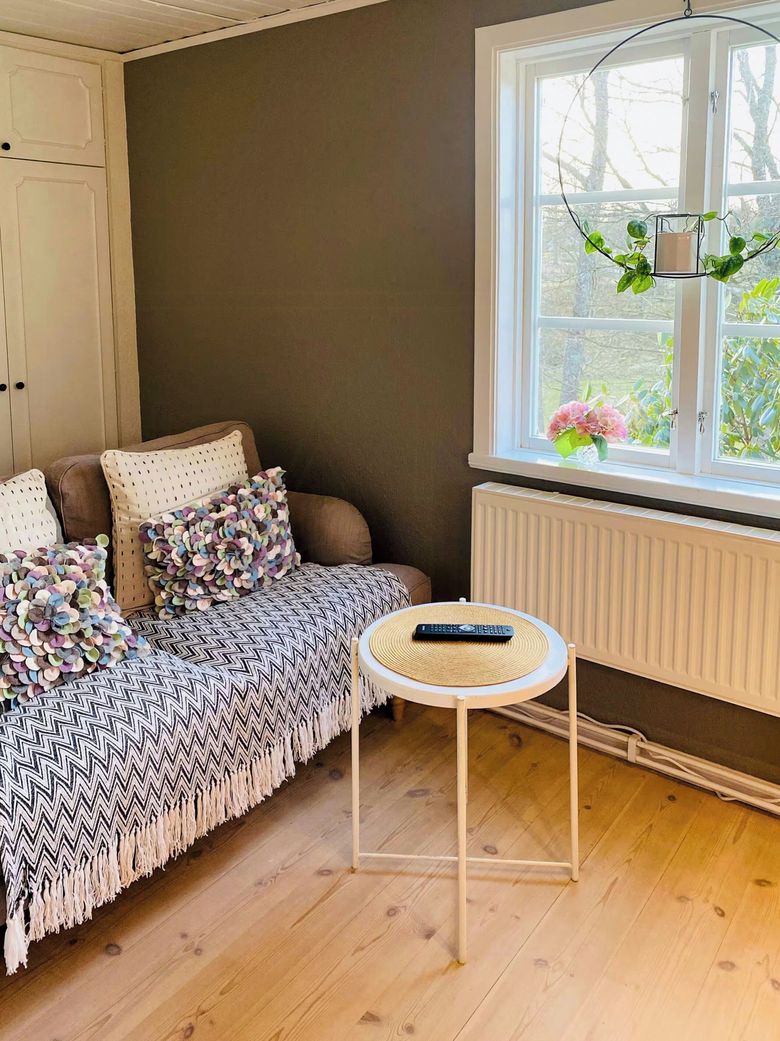 Una habitación acogedora con sofá, una mesita redonda y ventana con vistas a zonas verdes.
