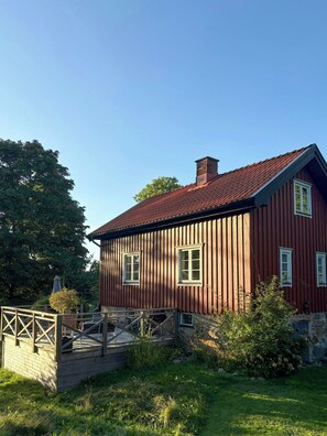 A red wooden house with a sloped roof and a chimney. - Guest house on farm near Gothenburg (Västra Götalands län)