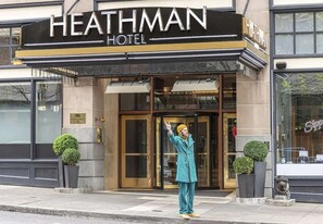 The entrance to the Heathman Hotel with a prominent sign, a glass door, and a person standing in front. - Steps to Powell’s & Art Museum | Pet-friendly. Gym (Portland)