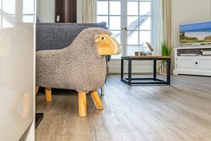 A room with a sofa, a small table, and a television. - Holiday apartment with 1 bedroom (Rantum, Sylt)