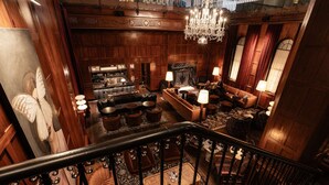 A grand lobby with a staircase, a fireplace, and a chandelier. - Downtown Views | Pet-friendly & In-Room Dining (Portland)