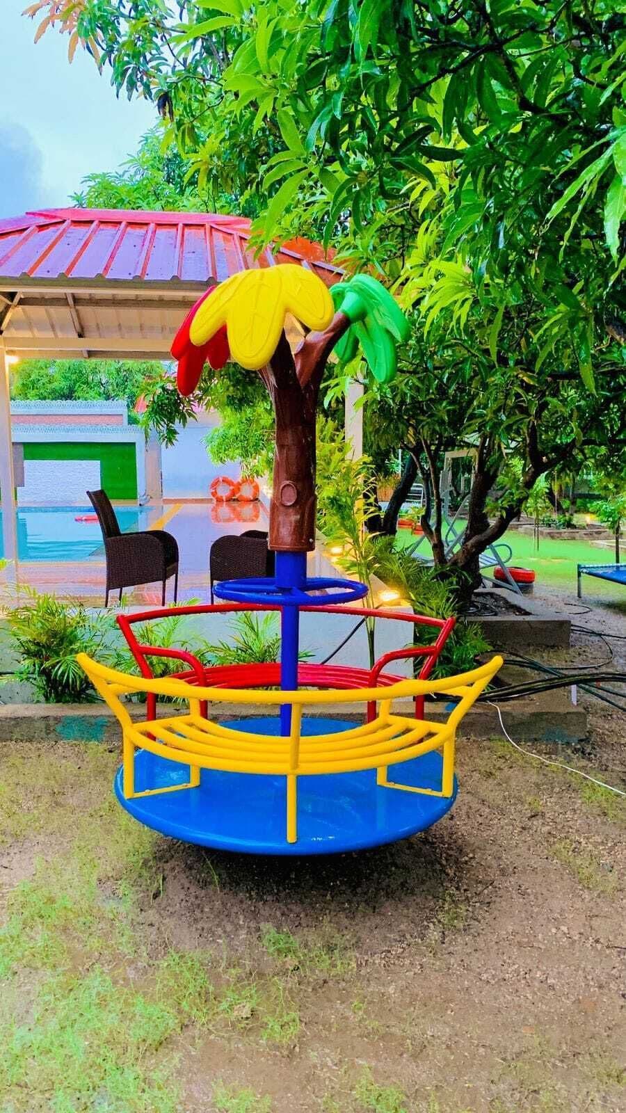 A colorful children's play structure with a tree-shaped top, a blue base, and yellow and red railings.