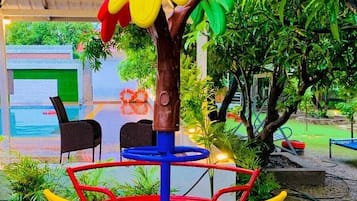 A colorful children's play structure with a tree-shaped top, a blue base, and yellow and red railings.