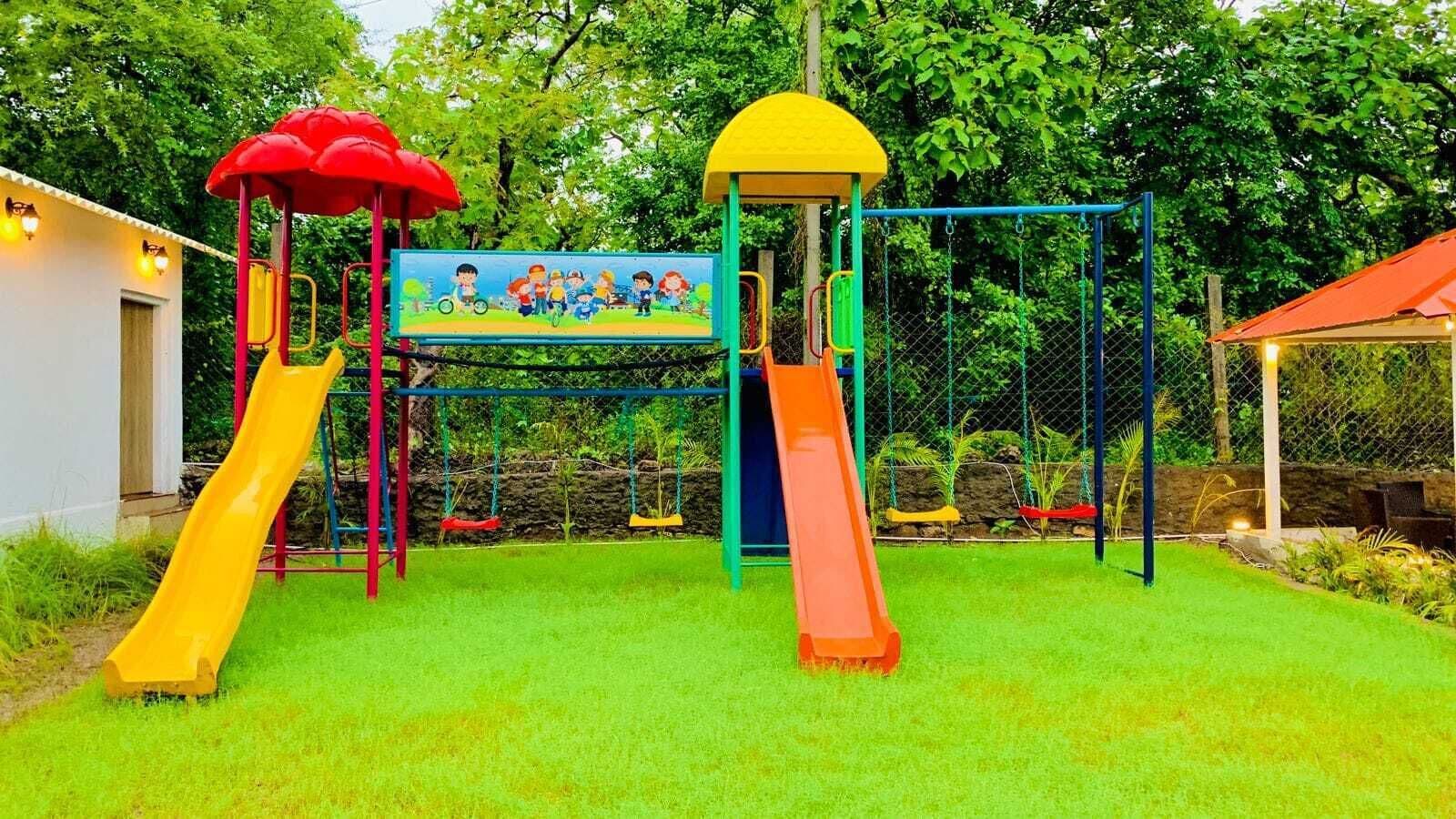 Un parque infantil con dos toboganes, una estructura para escalar y un mural.