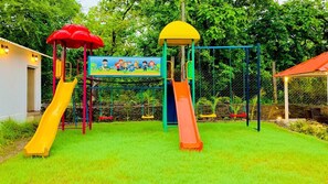 A playground with two slides, a climbing structure, and a mural.
