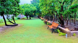 A park with benches and trees. - Sorathgadh Resort Sasan Gir- By Astirna Hospitality (Mendarda)