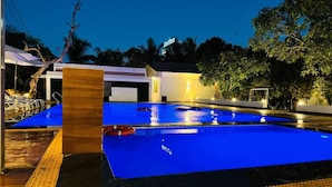 Ein Swimmingpool mit blauer Wasseroberfläche, umgeben von einer Liegefläche mit gelben Schutzgeländern.