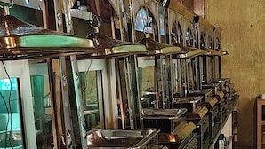 A row of bar-style furniture with reflective surfaces and a wooden ceiling. - Cottages & Cafe (Kotdwar)