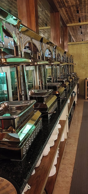 A row of bar-style furniture with reflective surfaces and a wooden ceiling. - Cottages & Cafe (Kotdwar)