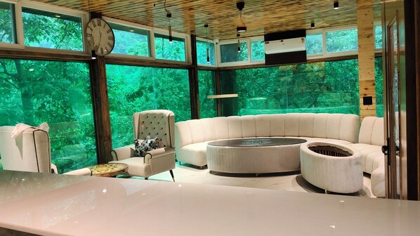 A modern interior with a large window, a round coffee table, and a tufted sofa.