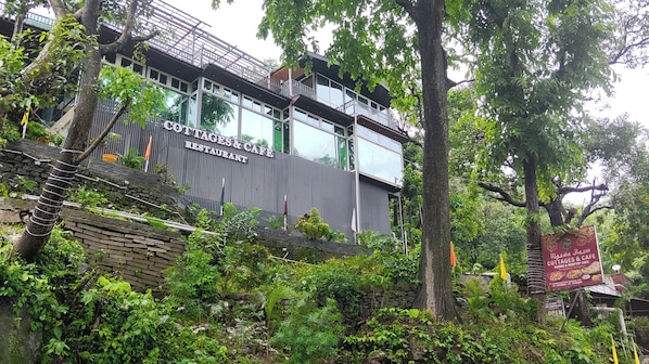 A multi-story building with a sign for 'COTTAGES & CAFE RESTAURANT' and a sign for 'MAASD RASOI COTTAGES & CAFE.' - Cottages & Cafe (Kotdwar)