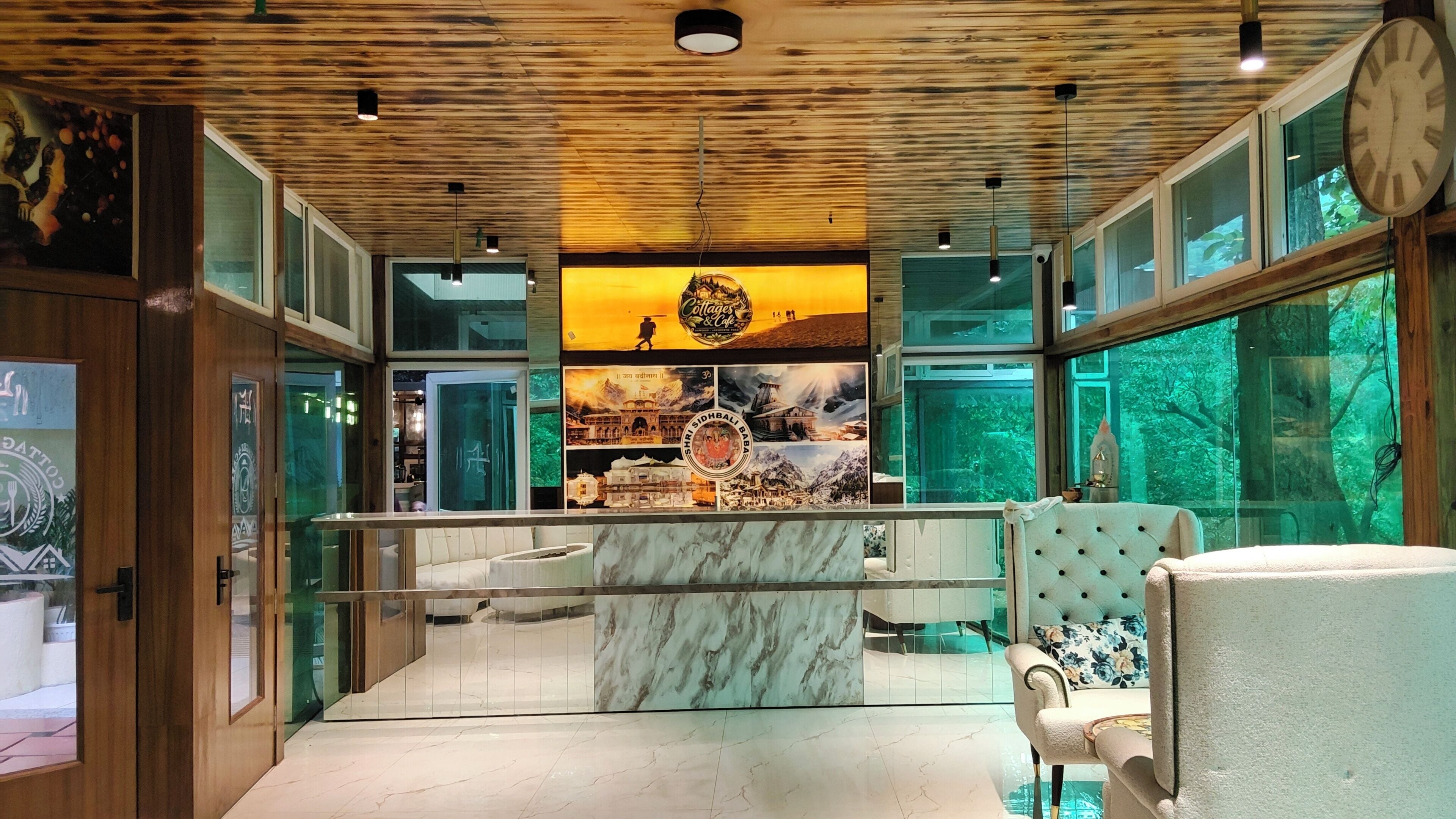 A modern interior with a wooden ceiling, a marble counter, and a view of a mountainous landscape through large windows.