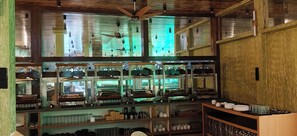 A bar area with multiple shelves stocked with glasses, bottles, and bar tools.