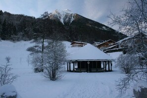A snow-covered lodge with a central pavilion and multiple cabins, surrounded by a mountainous landscape. - "Kehstein" in the "Bartmann" house (Ramsau)