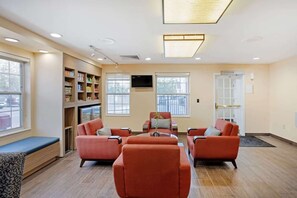 A modern living room with a sofa set, a coffee table, and a bookshelf.
