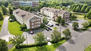A multi-story residential building with a parking lot and surrounding greenery. - Near Cherry Hill + Full Kitchens & Free Parking (Mount Laurel)