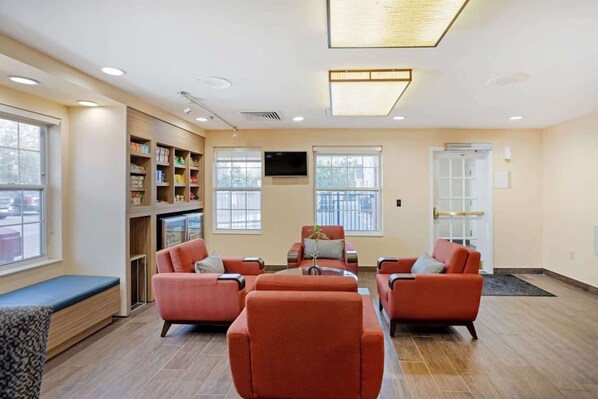A modern living room with a sofa set, a coffee table, and a bookshelf.