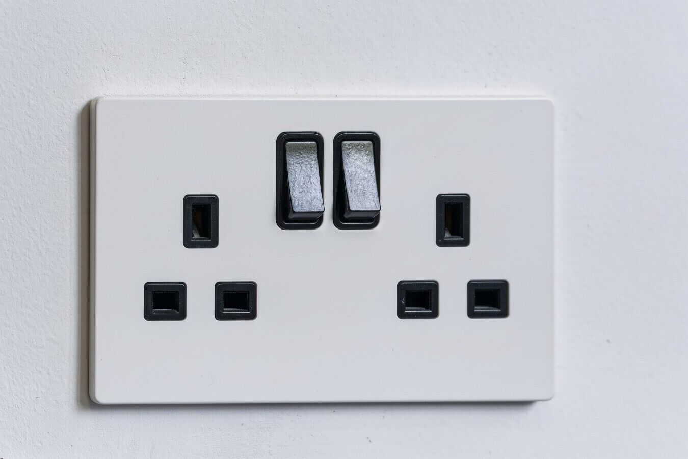 A white electrical outlet with two switches and four sockets.