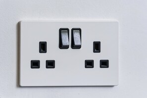 A white electrical outlet with two switches and four sockets. - Brand New Spacious Studio in Beeston (Beeston)