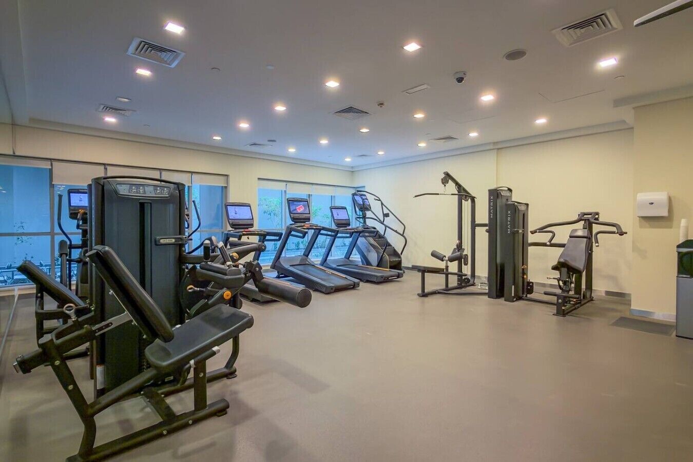 Une salle de sport équipée de tapis de course, d’appareils de musculation et d’autres équipements d’exercice.