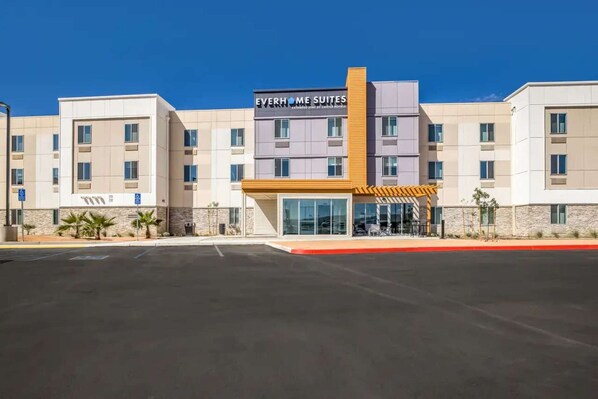 Een hotel met een modern design, met een opvallende entree met een overdekt gedeelte en een bordje met 'EverHome Suites'.