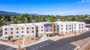 Un hotel con un letrero que dice 'EverHome Suites' y un estacionamiento con espacios reservados para discapacitados.