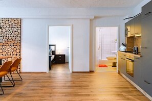 A modern kitchen with grey cabinets, a wooden countertop, and a microwave. - Holiday apartment with 1 bedroom (Warnemünde)