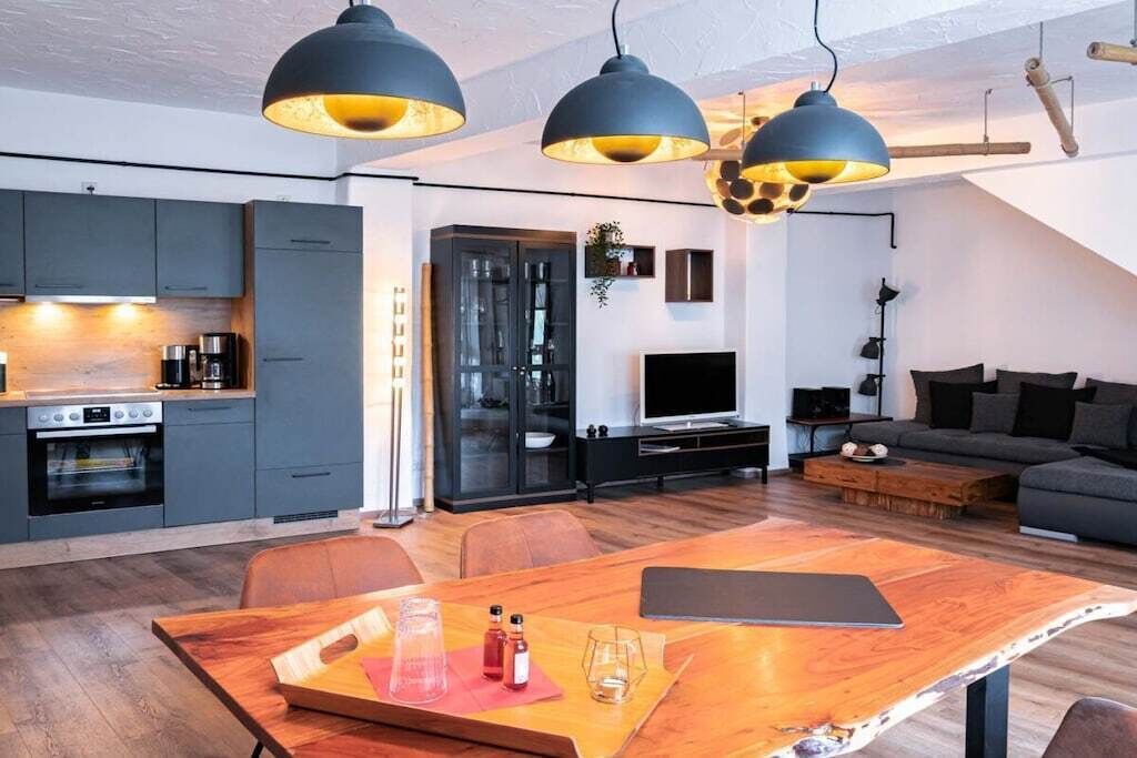 Un espai de vida modern amb cuina, zona de menjador i zona d'estar.