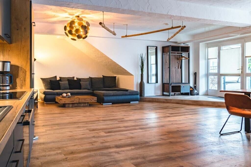 A modern living space with a sofa, coffee table, and a dining area.