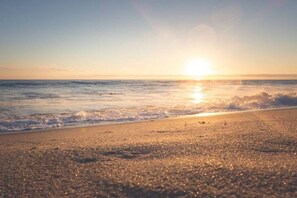 A beach with the sun setting over the ocean. - Holiday apartment with 1 bedroom (Warnemünde)
