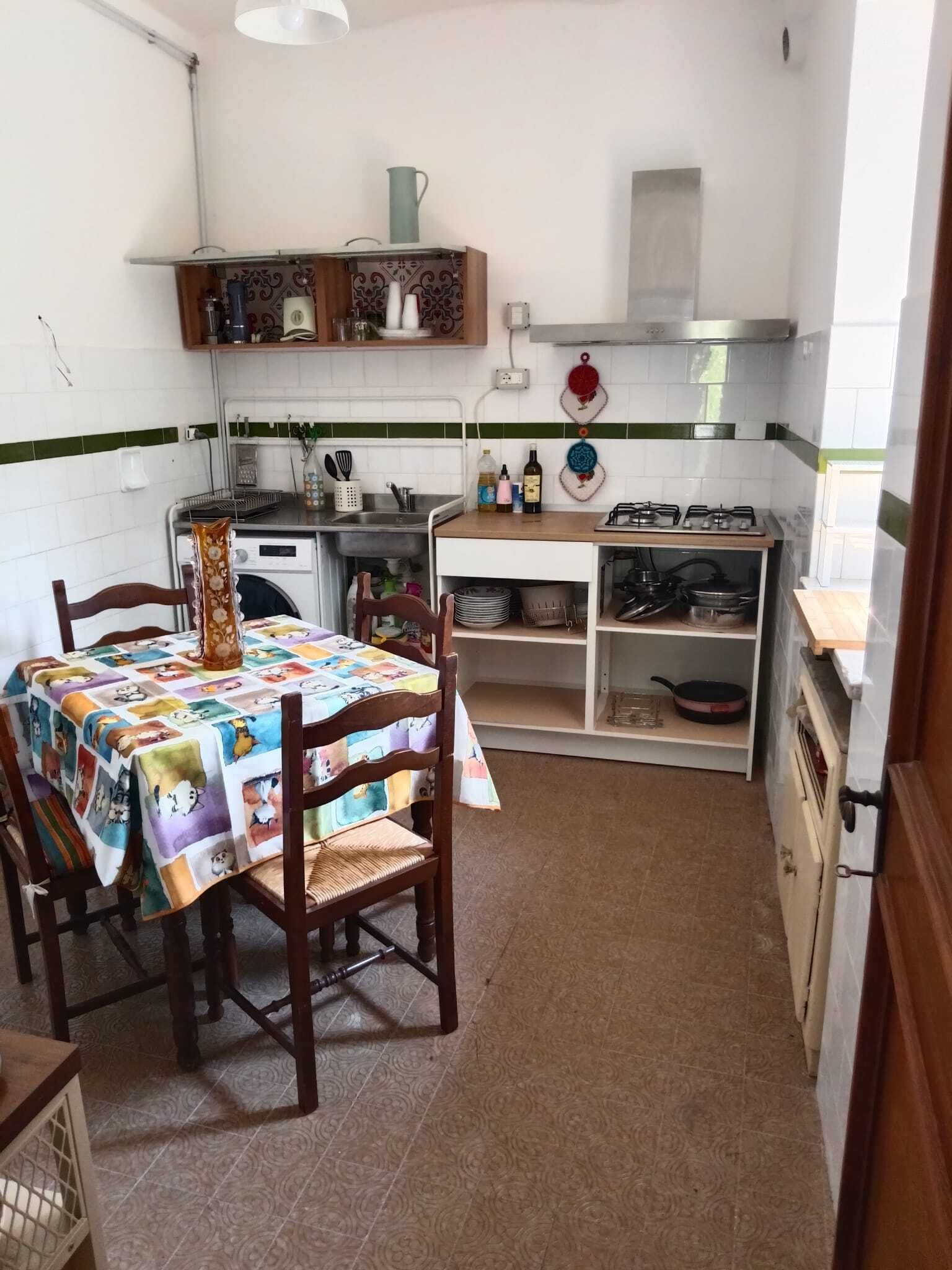 Una cucina funzionale con tavolo, sedie e diversi utensili.