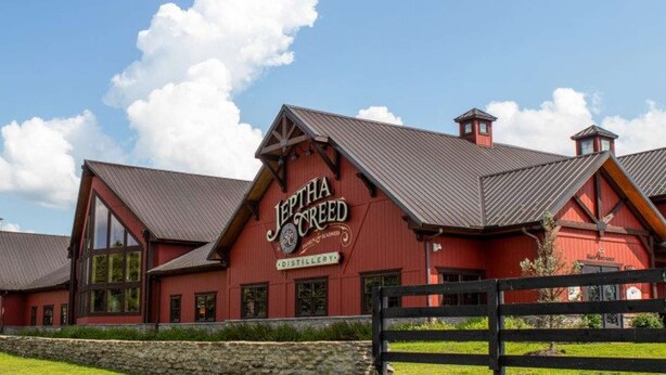 Un bâtiment rouge sur lequel on peut lire l’inscription : « Jeptha Creed Distillery ».