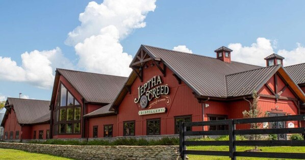 A red building with a sign that reads 'Jeptha Creed Distillery.'