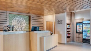 Un espace d’accueil doté d’un plafond en bois, d’un comptoir de réception, d’un élément décoratif fixé au mur et d’un distributeur automatique.