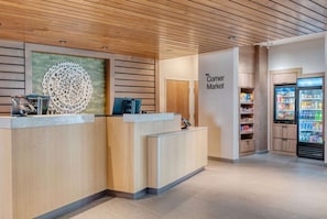 A reception area with a wooden ceiling, a reception desk, a wall-mounted decorative piece, and a vending machine. - Near Weissinger Hills Golf Course + Free Breakfast (Shelbyville)