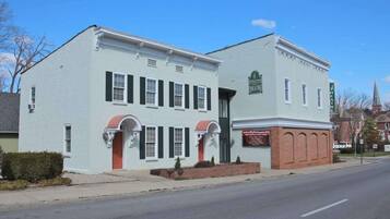 A two-story building with a flat roof, a brick section on the ground floor, and a sign indicating a theater.