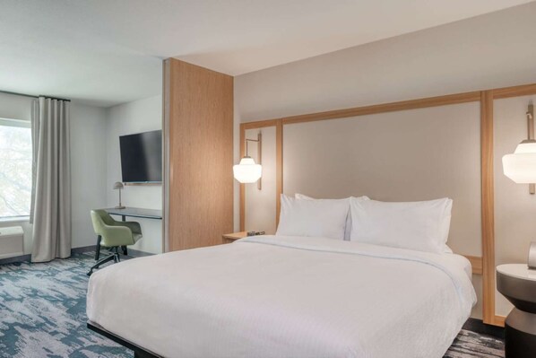 A hotel room with a large bed, a desk with a chair, a television, and a window with curtains. - Close to The Outlet Shoppes + Free Breakfast & Gym (Shelbyville)
