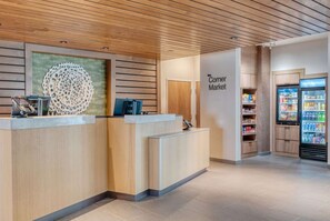 A reception area with a wooden ceiling, a reception desk, a wall-mounted decorative piece, and a vending machine. - Minutes to KFC Yum! Center + Free Breakfast & Gym (Shelbyville)