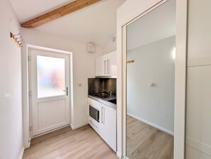 A compact kitchen with white cabinets, a stainless steel sink, and a built-in oven. - Comfortable studio with free parking (Berkshire)