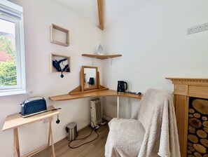A room with a wooden desk, a radiator, a chair with a towel, and a fireplace. - Comfortable studio with free parking (Berkshire)
