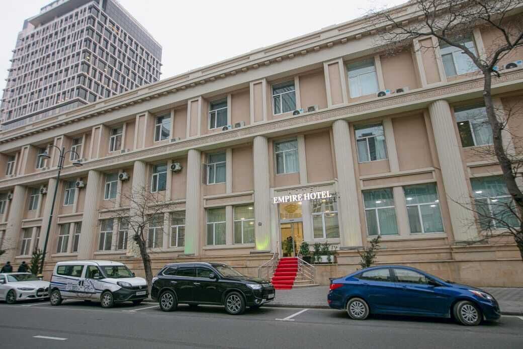 Un edificio con un cartel que dice 'EMPIRE HOTEL' y una escalera que lleva a la entrada.