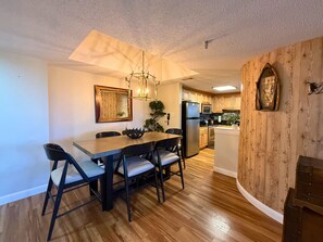 Una cocina moderna con armarios de madera, un refrigerador de acero inoxidable y un microondas.